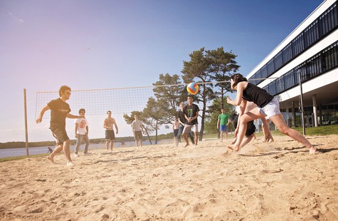 Foto på studenter som spelar volleyboll utanför skolan