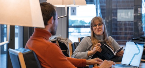 Kille och tjej studerar i biblioteket