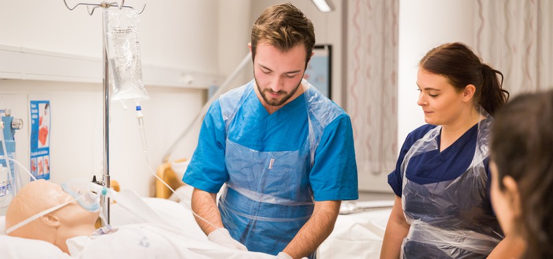 Två sjuksköterskestudenter behandlar en artificiell patient