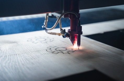 Bild på CNC-maskin som fräser ett kugghjul i trä i maskinlabbet