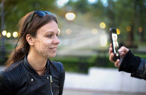 Kvinna som får sitt ansikte skannat med en telefon