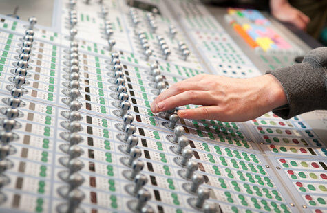 Hand vid ett mixerbord med många knappar