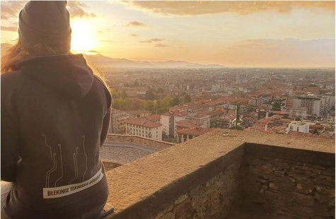 Student sitter på en mur i Italien